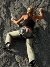 climber using friction to hold on to vertical cliff