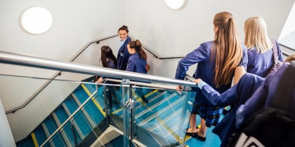 Pupils in purple school uniform descend staircase