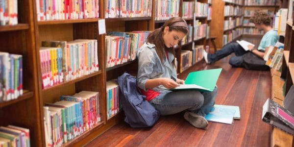 University students reading notes in a library
