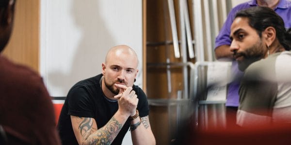 Adult man with tattoos in support group session
