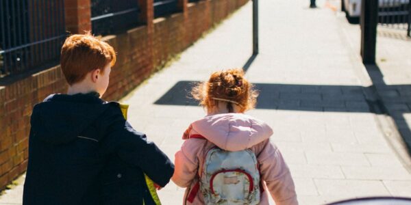 Brother and sister walking on the pavement