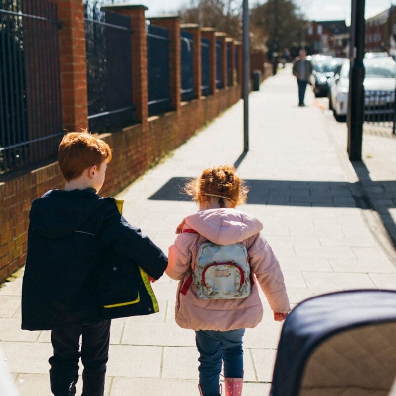 Brother and sister walking on the pavement