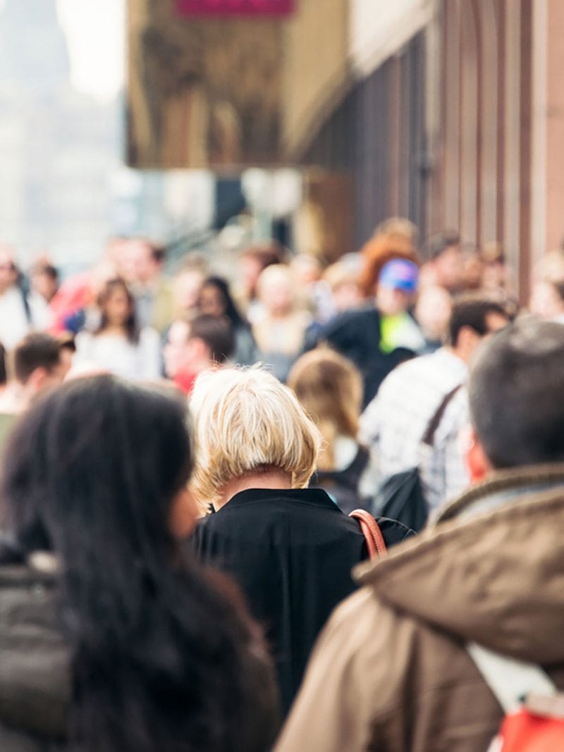 Blurry crowd of pedestrians on busy city street