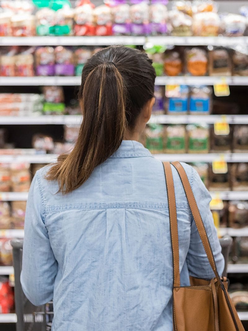 Woman facing supermarket aisles