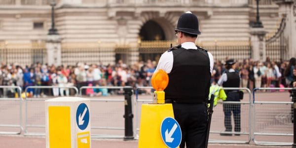 Metropolitan policeman standing guard with a crowd nearby
