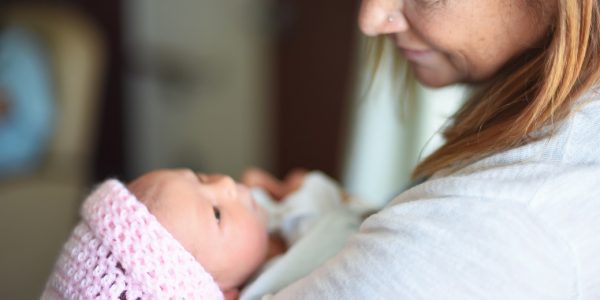 Adult holding newborn baby