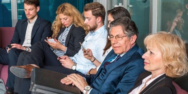 People looking at their mobile phones while waiting for job interview