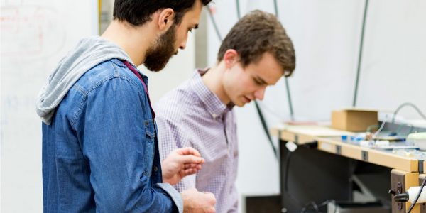 Two teenage male pupils study a science lesson as part of their post-16 options