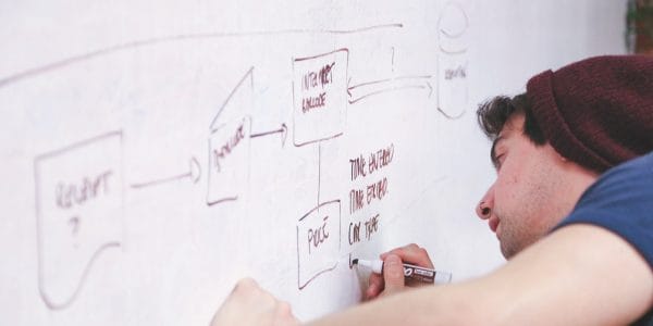 Teenage-pupil-wearing-woolly-hat-writes-on-whiteboard-The-influence-of-headteachers-on-their-schools-PROJ