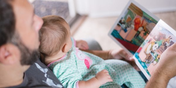 man reading picture book to baby
