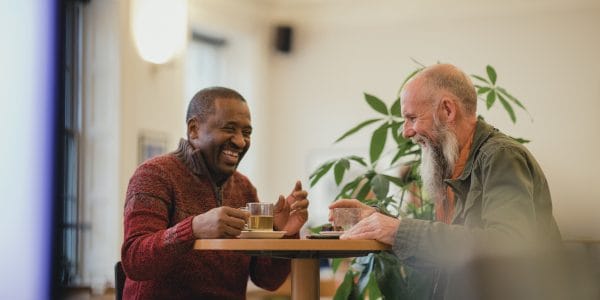 Two-senior-men-laughing-cafe-arthritis