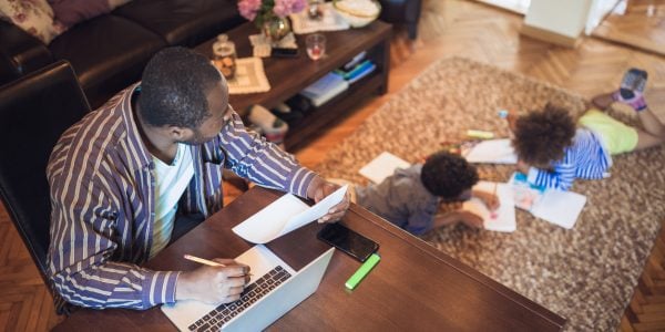 Father-working-from-home-while-his-two-children-do-schoolwork-nearby-COVID-19-social-study-PROJ