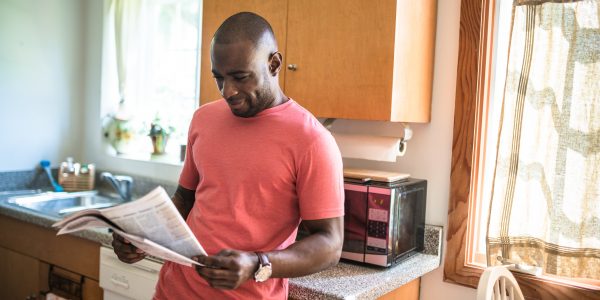 Man reading the newspaper in the kitchen