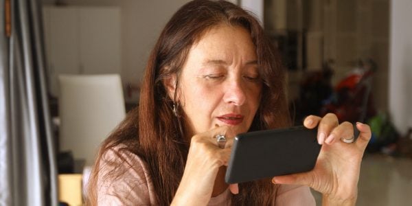 Woman-looks-at-smartphone-screen-How-the-UK-public-gets-information-about-COVID-19-PROJ