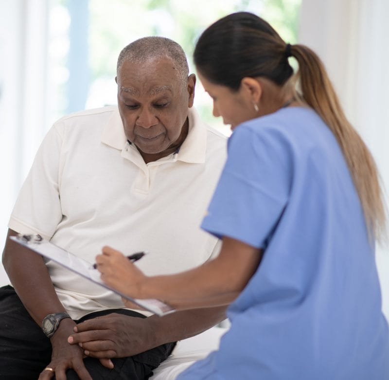 A senior gentleman speaks with his doctor during a routine check-up in the doctors office