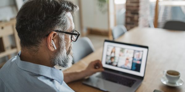 Mature man at home during pandemic isolation have conference call