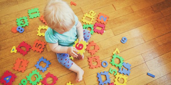 Pre-school child playing with game to improve early numerical skills