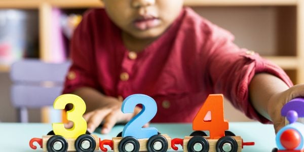 Little boy playing mathematics wooden toy at nursery