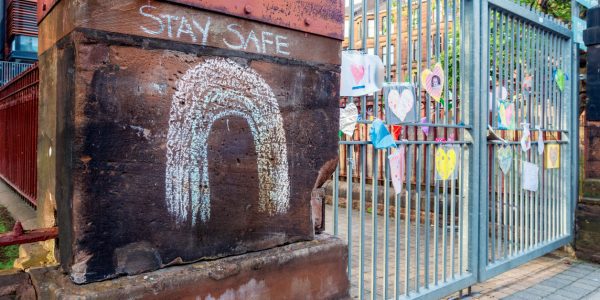 Image of school gates and with chalk writing 'stay safe' schools re-opening