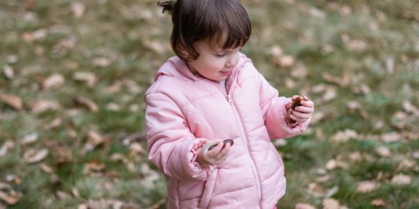 Girl holds acorns in her hand in the park