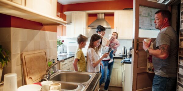 Code encounters algorithmic risk-profiling in housing: a family in their kitchen at home