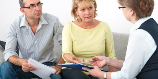 A divorcing couple in a meeting with a legal professional, seeking advice on pensions on divorce