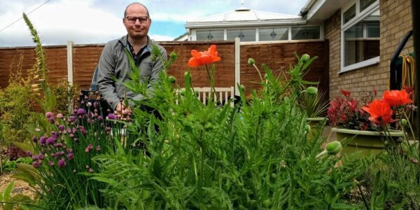 Colin Wilkinson research partner for Versus Arthritis sitting in his garden