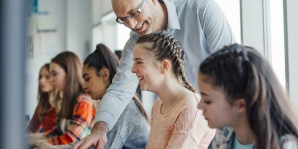 A female pupil is sitting behind a computer in a lesson