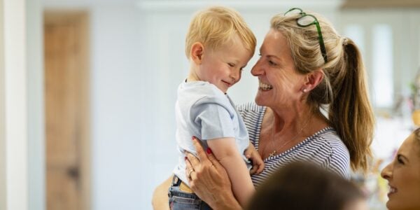 A woman holding a small boy, both looking very happy