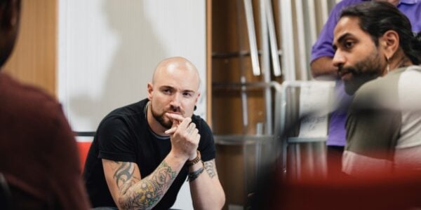 Young men looking puzzled as they look to another man for advice