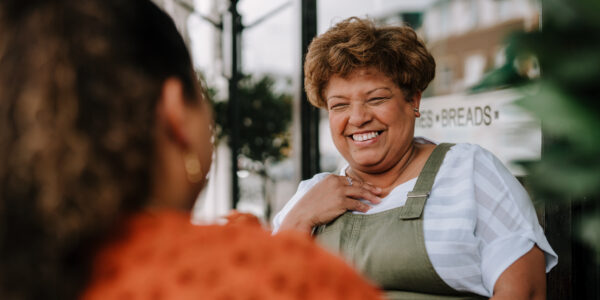Two women talk outside a cafe