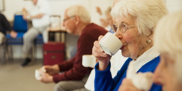 Older people drinking tea at a meeting at a community centre