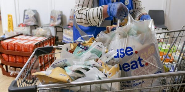 Food bank worker puts food into a trolley
