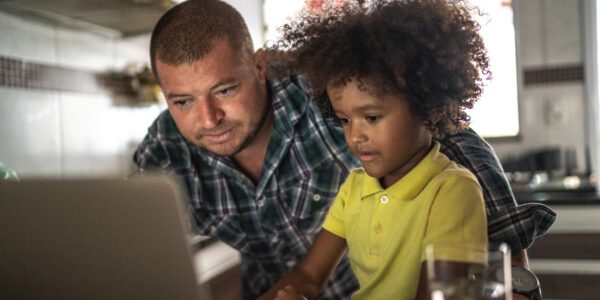Father and son using laptop at home
