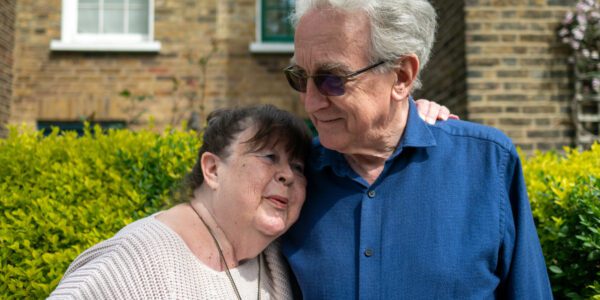 Older man and woman standing outside home innocation adult social care