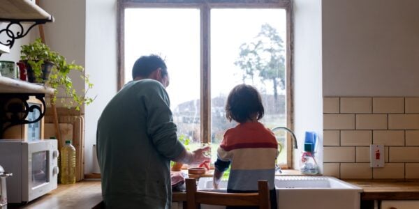 Father and child washing up in the kitchen