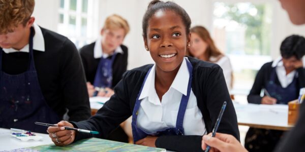 Teenage girl and classmates in art lesson at secondary school