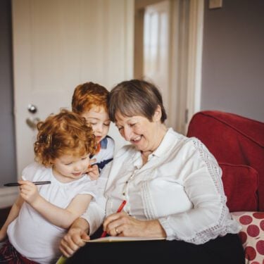Grandmother with little children with pen and paper