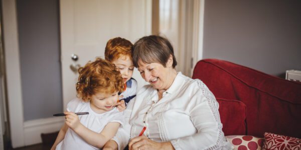 Grandmother with little children with pen and paper
