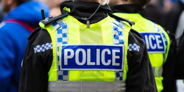 Police officer wearing a yellow vest with police wrote on the back