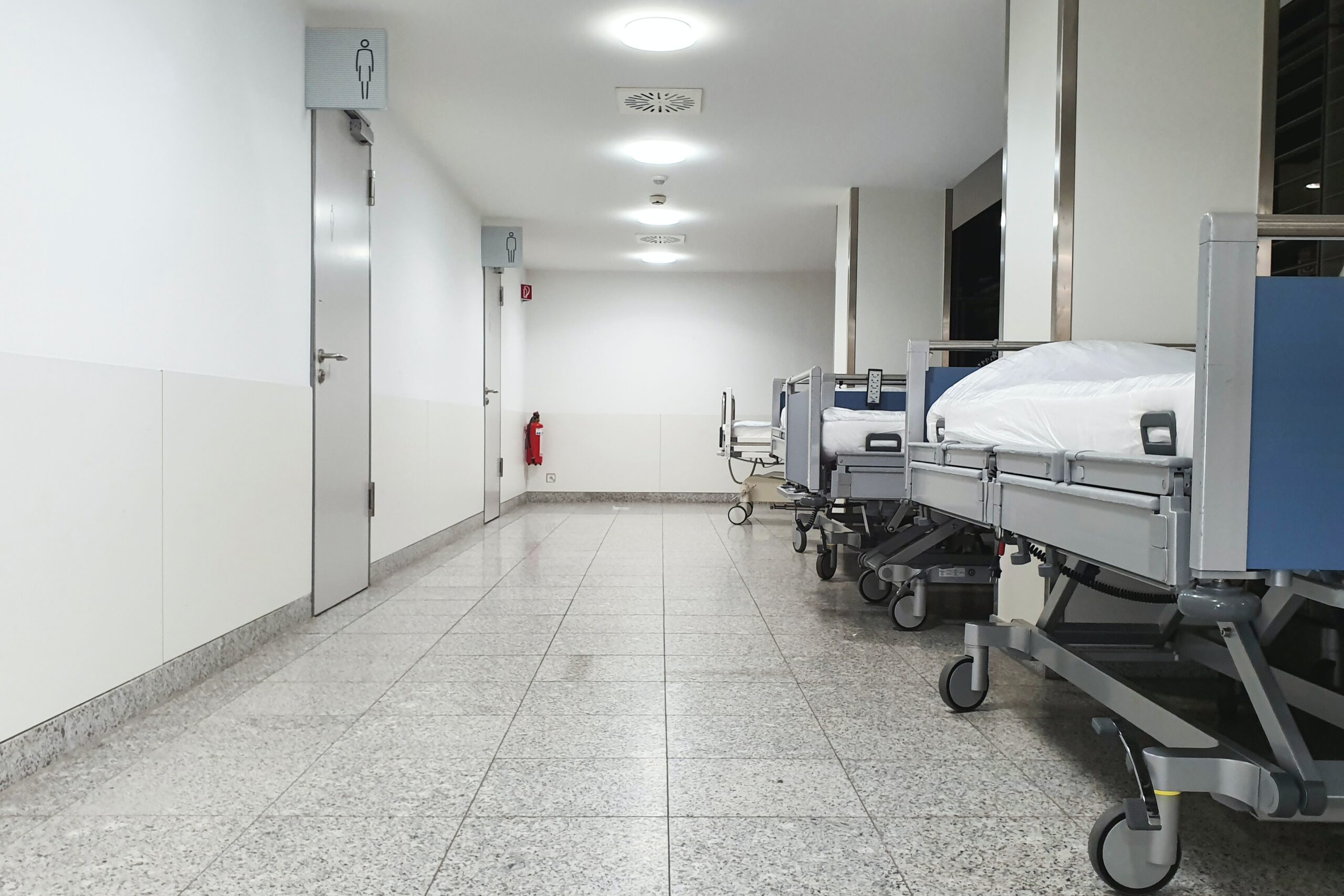 Empty hospital beds in hospital corridor
