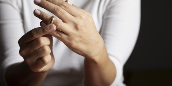 woman removing her wedding ring from her ring finger