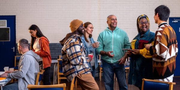 People standing together smiling and talking in a community centre