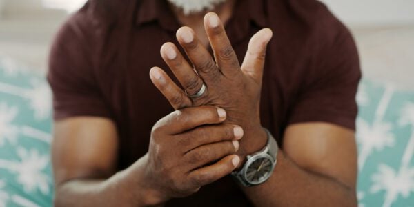 Cropped shot of a man sitting alone on his sofa at home and suffering from arthritis in his hand.