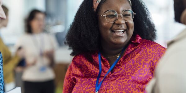 Happy woman talking to a colleague at work
