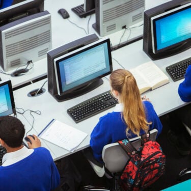 Elevated view of students sitting and learning in computer room