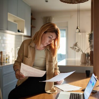 Close up of a Young woman going over her retirement savings at home while using her laptop