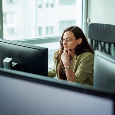 Young well dressed businesswoman working on a computer at the office
