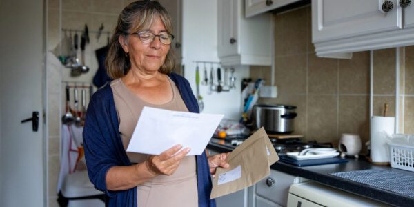 Portrait of a senior woman at home checking a letter in the mail
