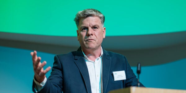 CEO Gavin Kelly by a podium speaking